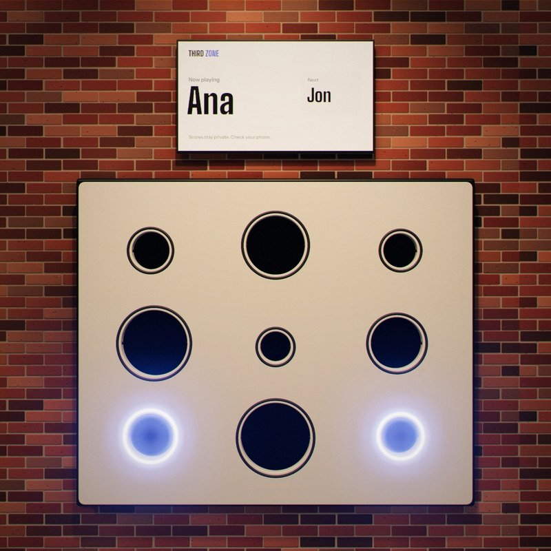 The wall with two smaller targets lit. The screen above reads: Now playing, Ana.