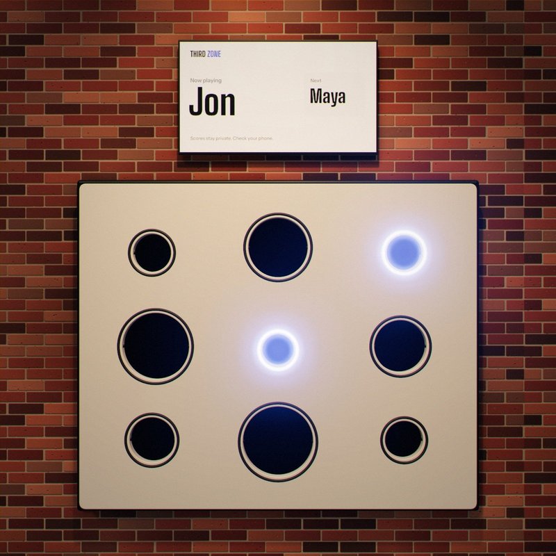 The wall with the two smallest targets lit. The screen above reads: Now playing, Jon.
