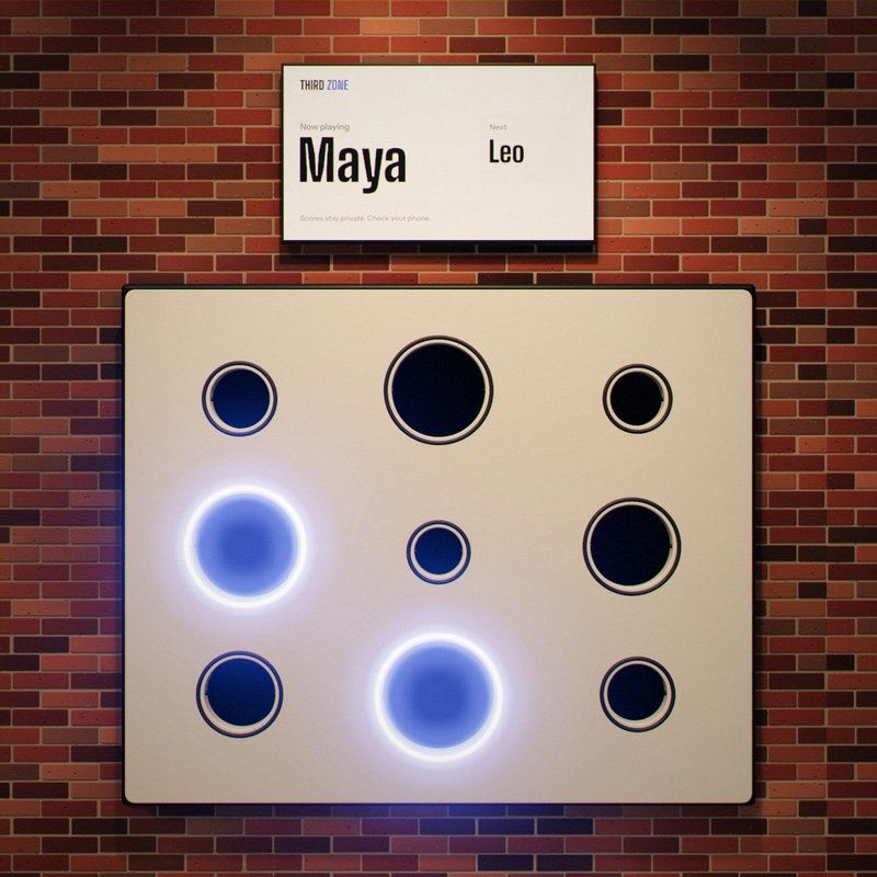 The wall with the two largest targets lit. The screen above reads: Now playing, Maya.